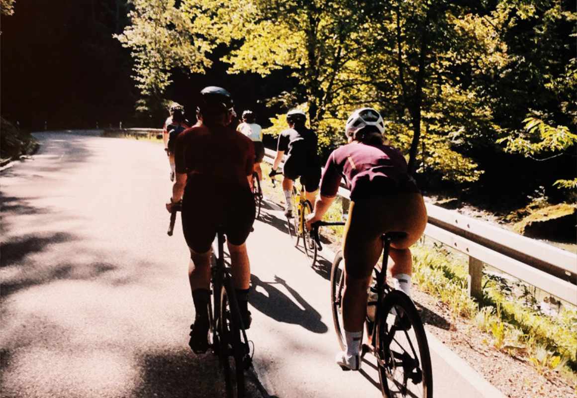 Frauen auf Rennrad fahren in der Gruppe bergab.
