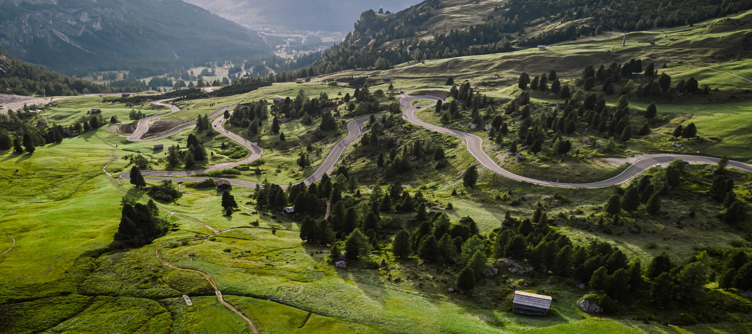Serpentinen eines Passes schlängeln sich durch Landschaft im Hintergrund Bergpanorama